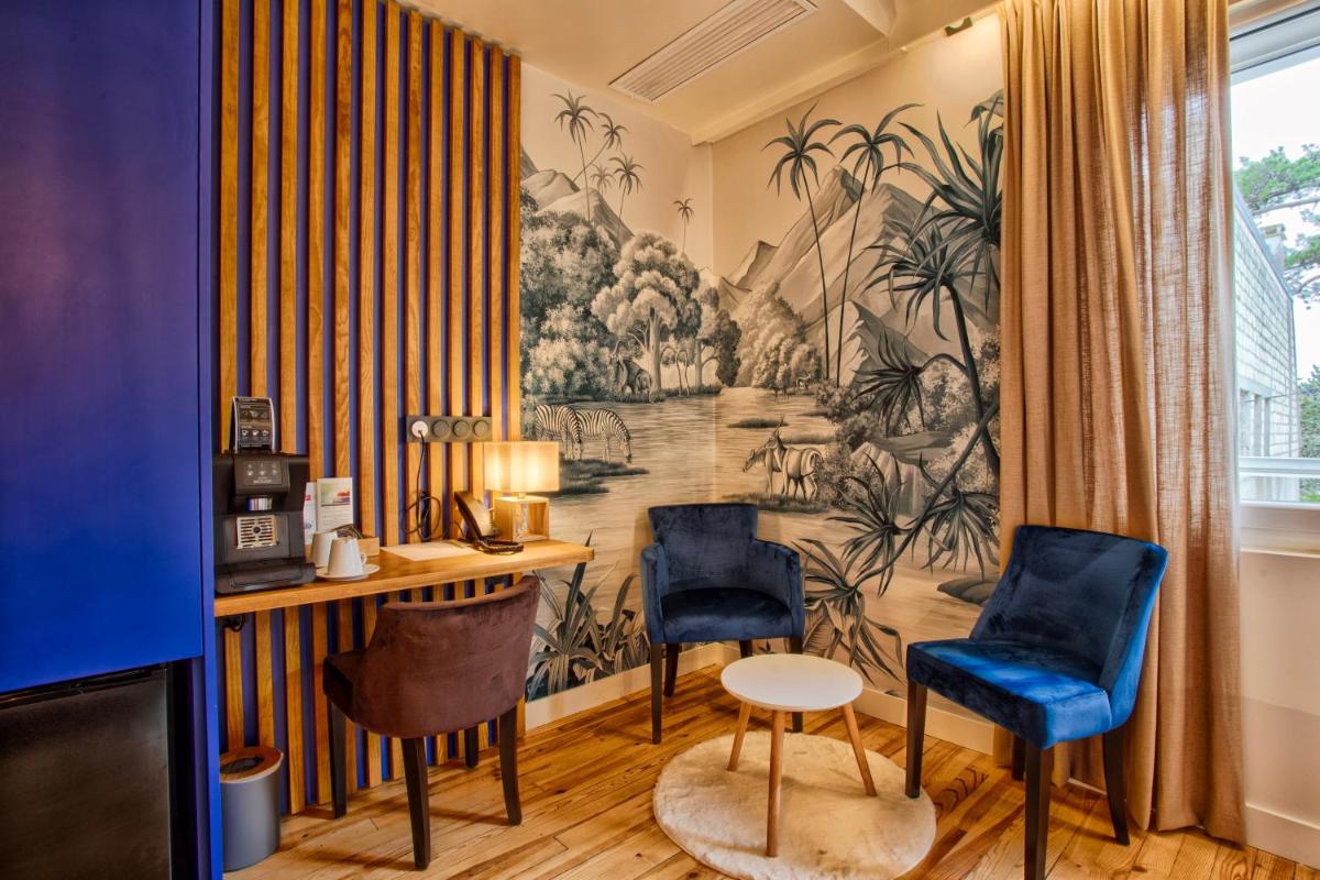 une pièce avec deux chaises bleues et une fresque murale dans l'établissement Le Castel Cabourg hôtel & SPA- Restaurant La Calypso, à Cabourg