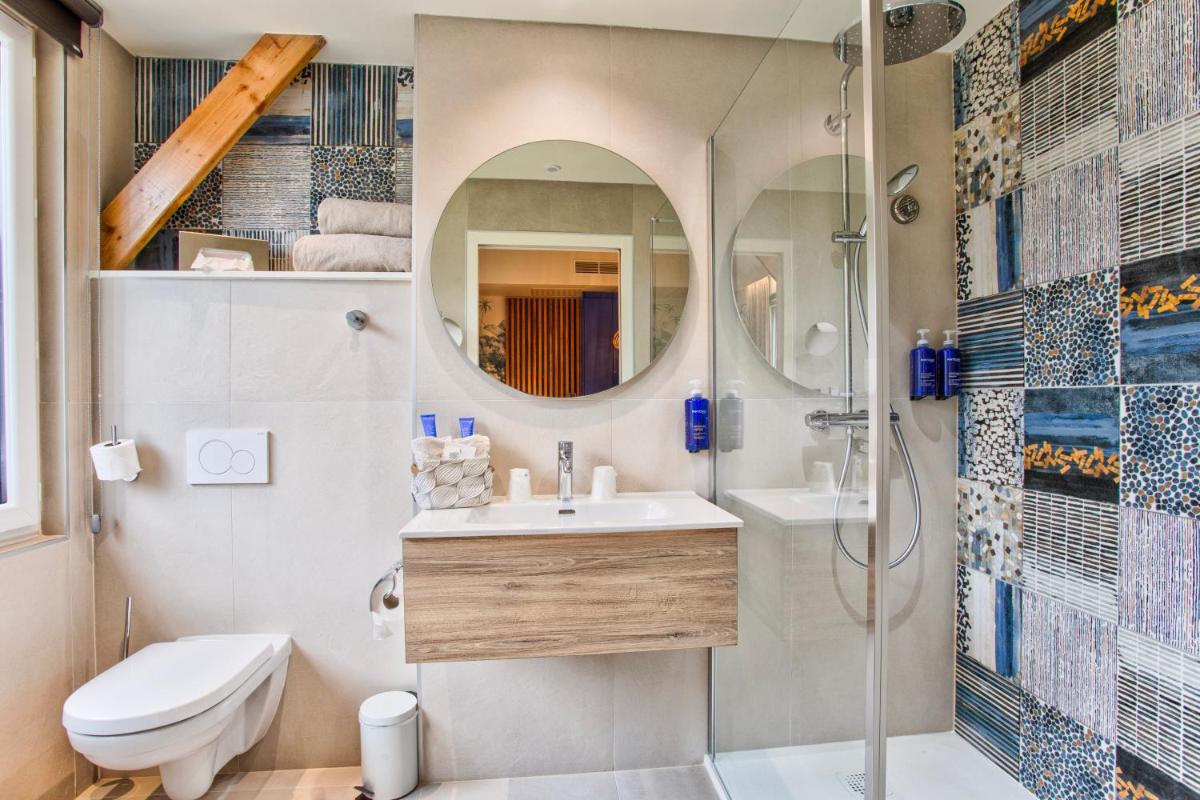 une salle de bain avec une douche, un lavabo et des toilettes dans l'établissement Le Castel Cabourg hôtel & SPA- Restaurant La Calypso, à Cabourg