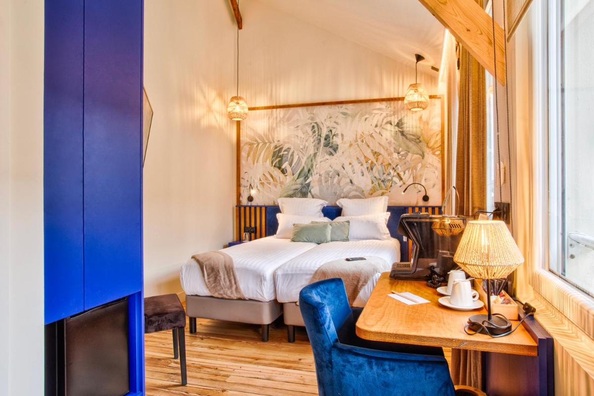 Un ou plusieurs lits dans un hébergement de l'établissement Le Castel Cabourg hôtel & SPA- Restaurant La Calypso