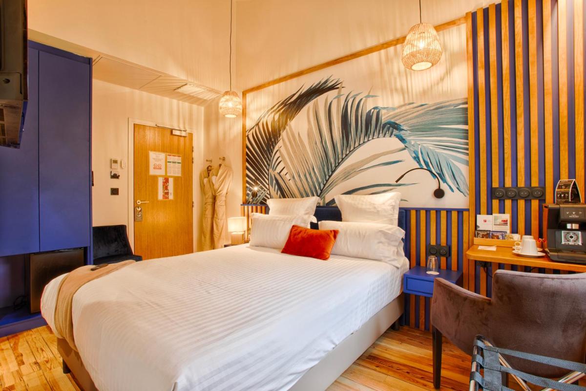 une chambre avec un grand lit avec un tableau au mur dans l'établissement Le Castel Cabourg hôtel & SPA- Restaurant La Calypso, à Cabourg