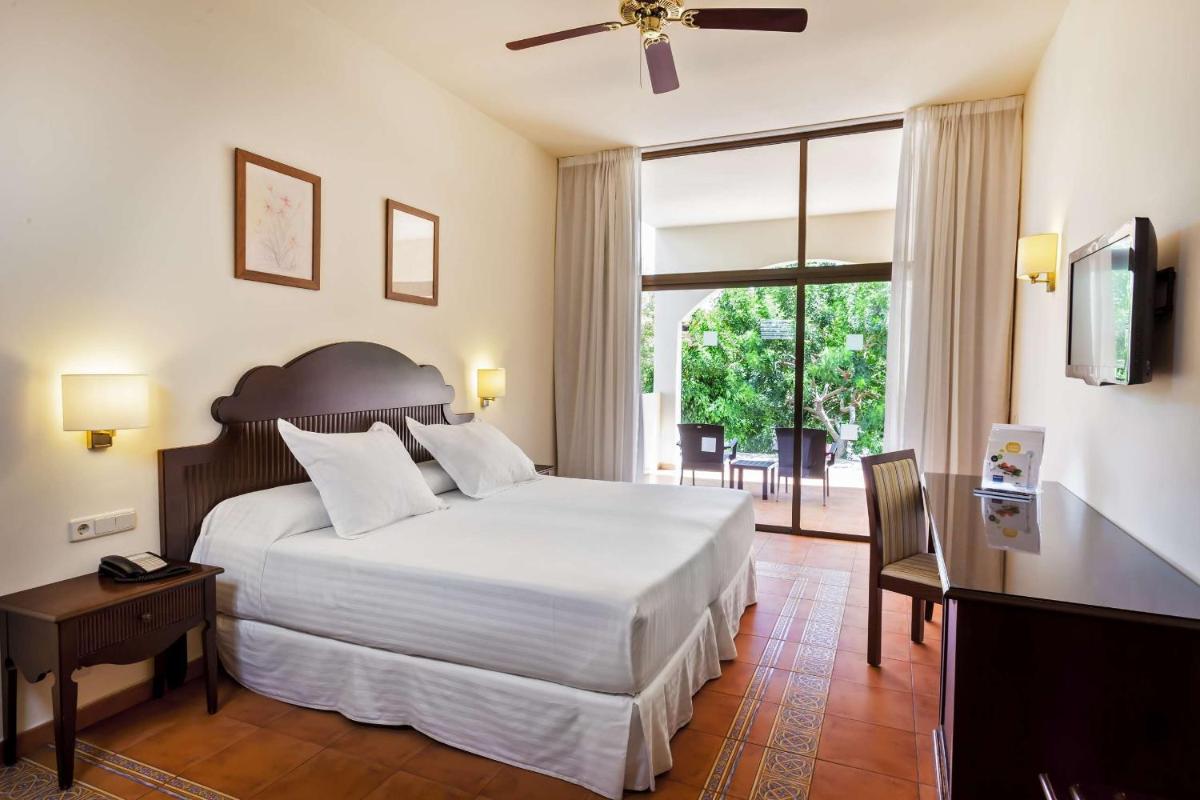 Un dormitorio con una cama y un escritorio y una ventana. en Occidental Jandía Mar, en Morro del Jable