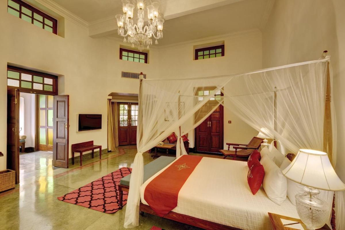 a bedroom with a bed and a chandelier at Saraca Hotel Lucknow in Lucknow