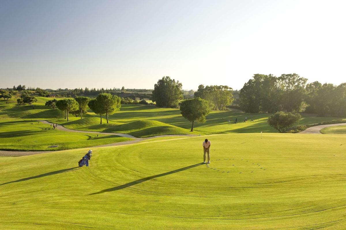 un hombre parado en un campo de golf verde en Barceló Jerez Montecastillo & Convention Center, en Jerez de la Frontera