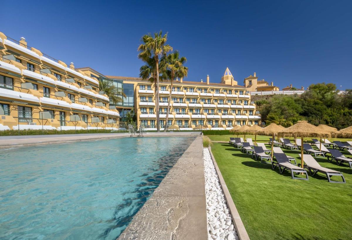 Un resort con sillas y piscina y un edificio. en Barceló Jerez Montecastillo & Convention Center, en Jerez de la Frontera