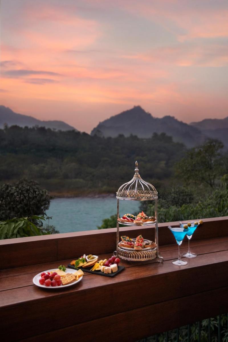 a table with plates of food and a drink at Anand Kashi by the Ganges Rishikesh - IHCL Seleqtions in Rishīkesh