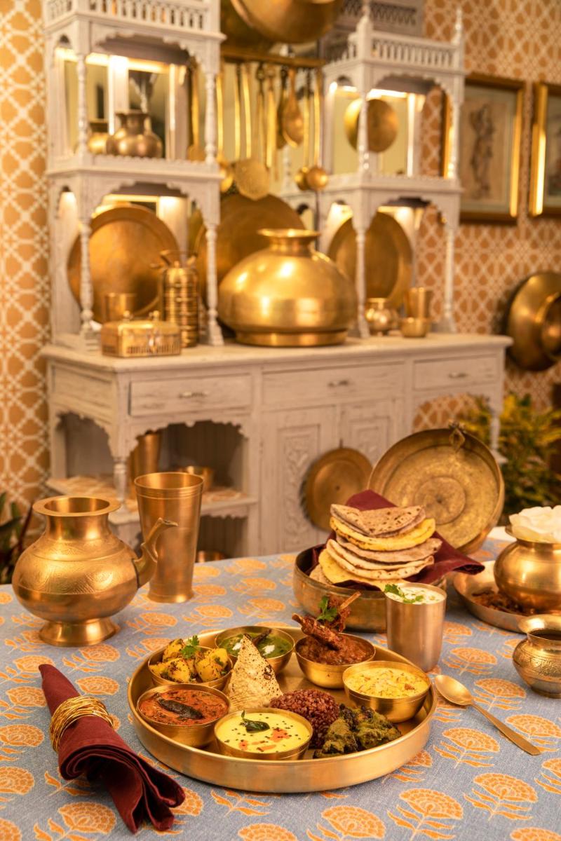 a table with a plate of food on a table at Anand Kashi by the Ganges Rishikesh - IHCL Seleqtions in Rishīkesh