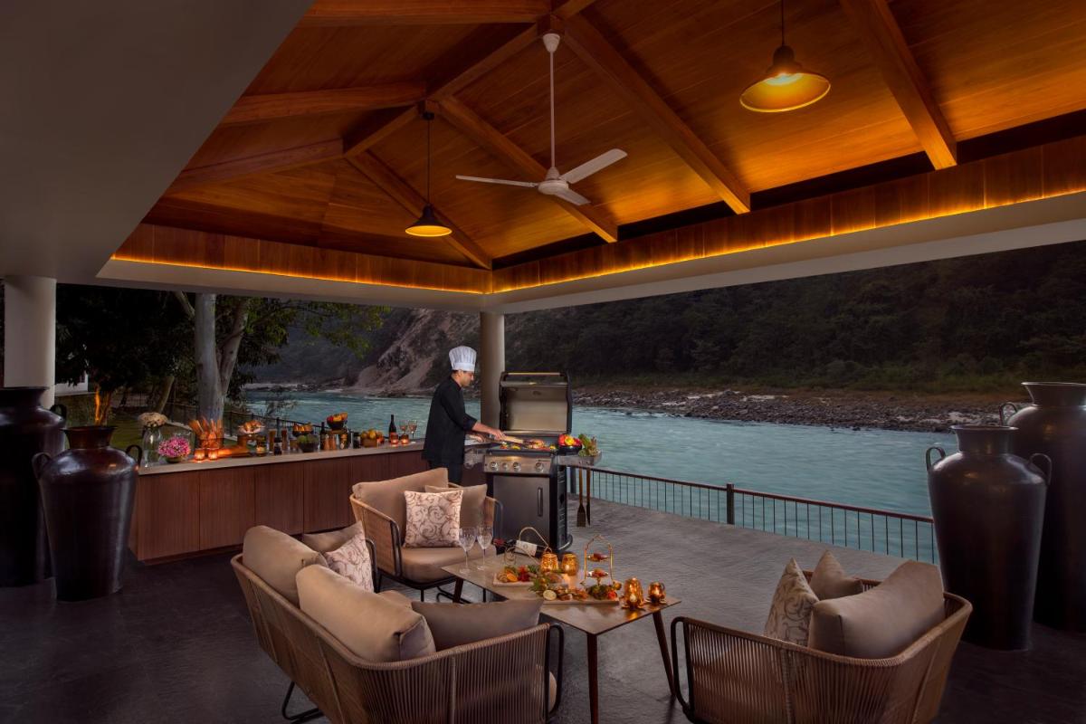 a person standing on a patio with a grill at Anand Kashi by the Ganges Rishikesh - IHCL Seleqtions in Rishīkesh