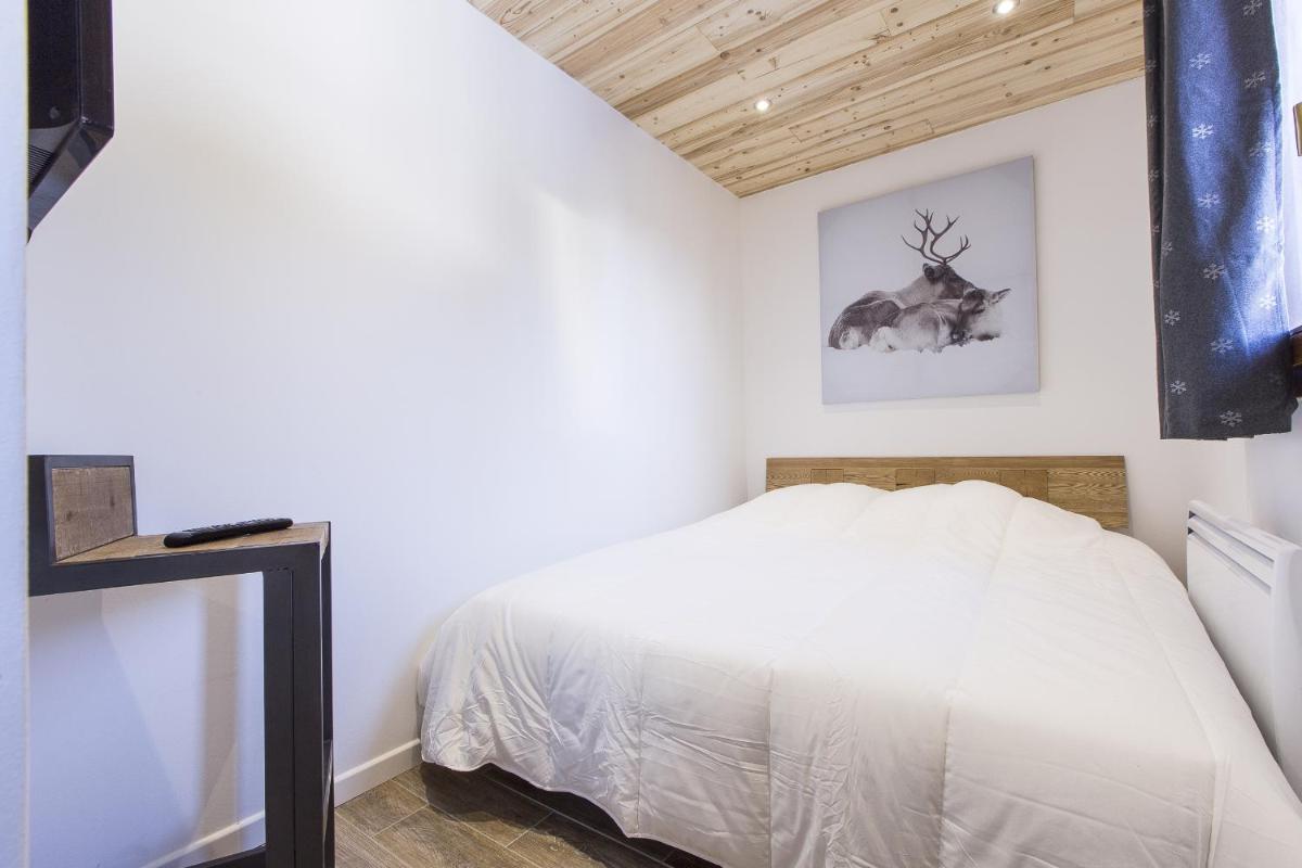 - une chambre avec un lit et une photo de cerf sur le mur dans l'établissement Résidence Le Domaine du Jardin Alpin - Courchevel 1850, à Courchevel