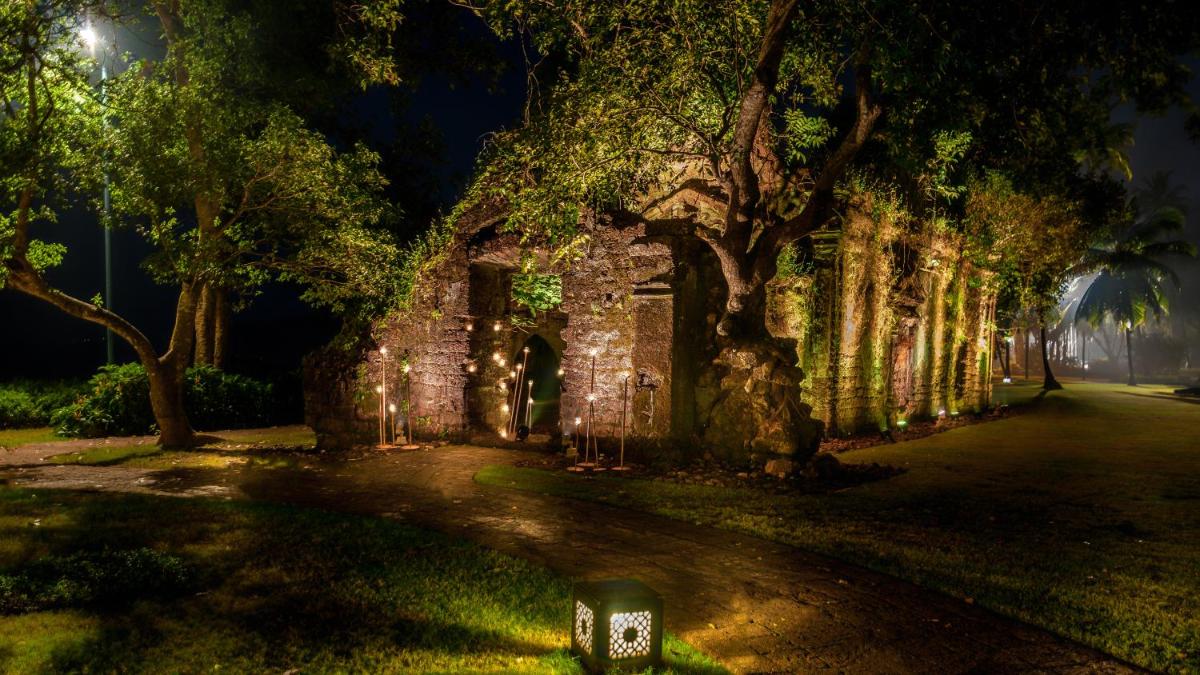 an old stone building with trees and lights at Grand Hyatt Goa in Panaji an old stone building with trees and lights at Grand Hyatt Goa in Panaji