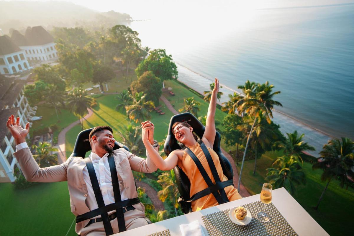 a group of people sitting at a table with their hands in the air at Grand Hyatt Goa in Panaji a group of people sitting at a table with their hands in the air at Grand Hyatt Goa in Panaji