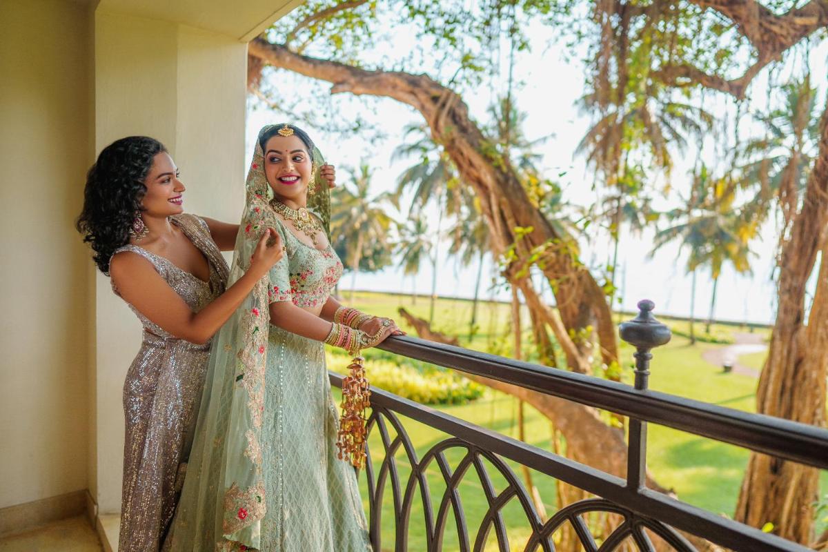 two women standing next to each other on a balcony at Grand Hyatt Goa in Panaji two women standing next to each other on a balcony at Grand Hyatt Goa in Panaji
