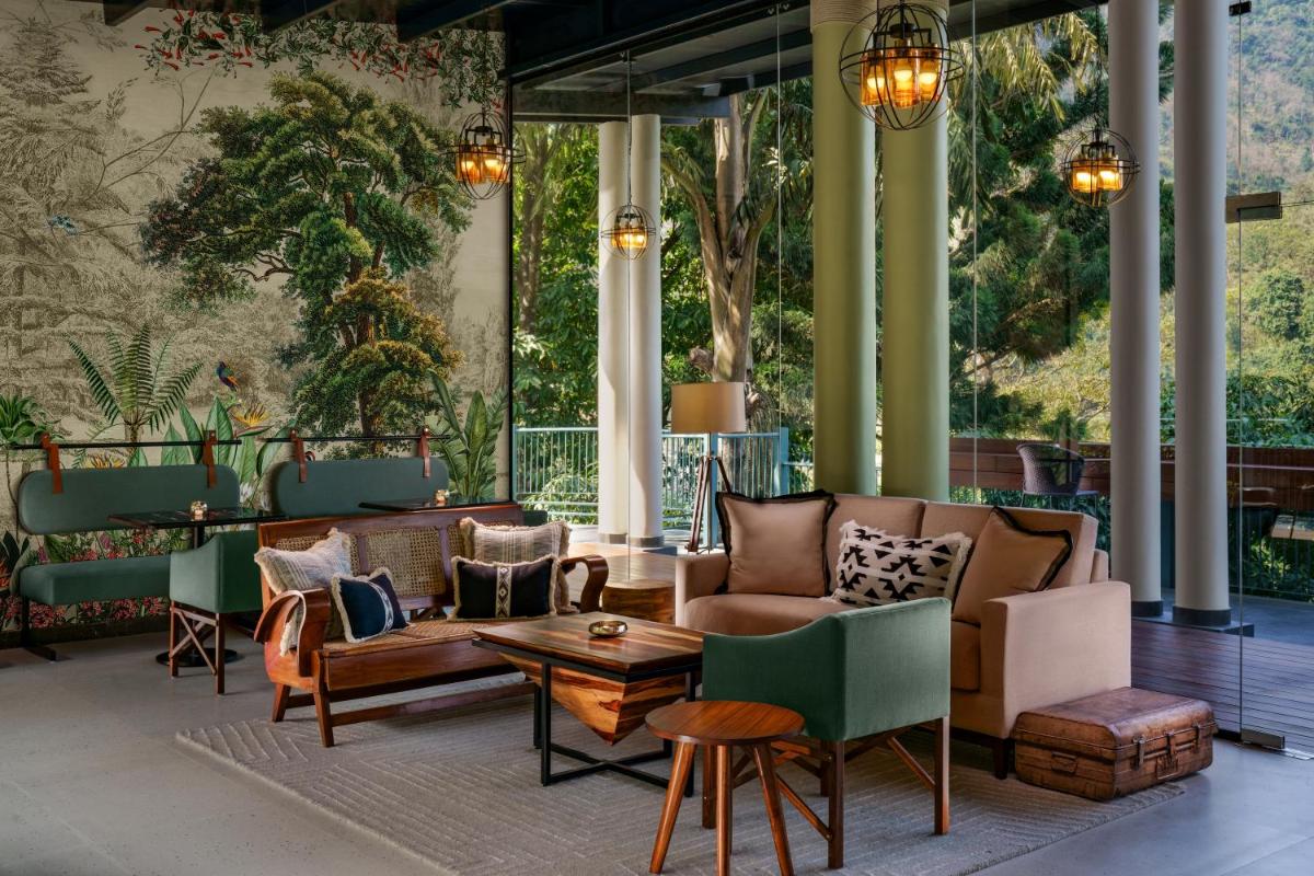 a lobby with couches and chairs and a table at Anand Kashi by the Ganges Rishikesh - IHCL Seleqtions in Rishīkesh