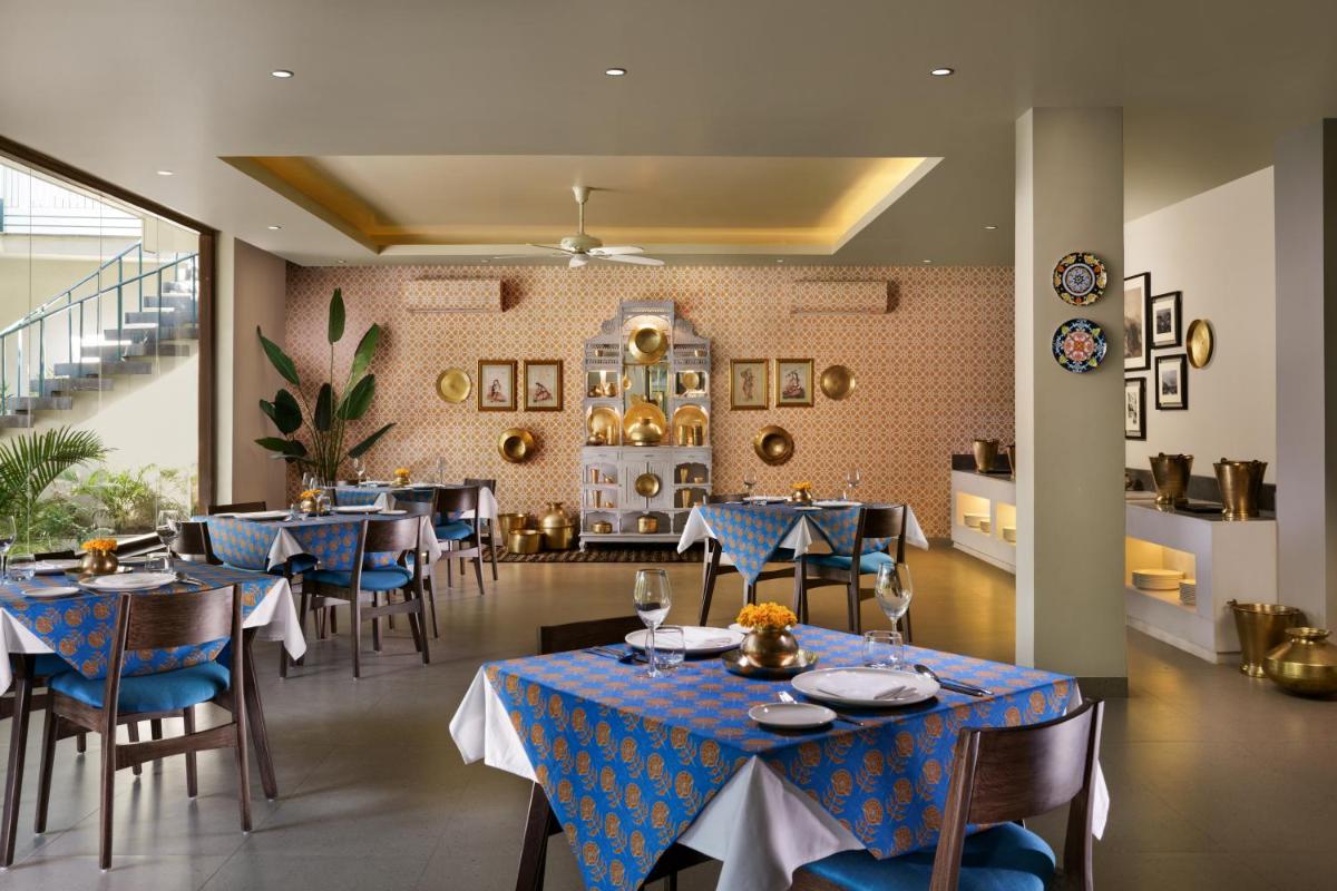 a dining room with blue tables and chairs at Anand Kashi by the Ganges Rishikesh - IHCL Seleqtions in Rishīkesh