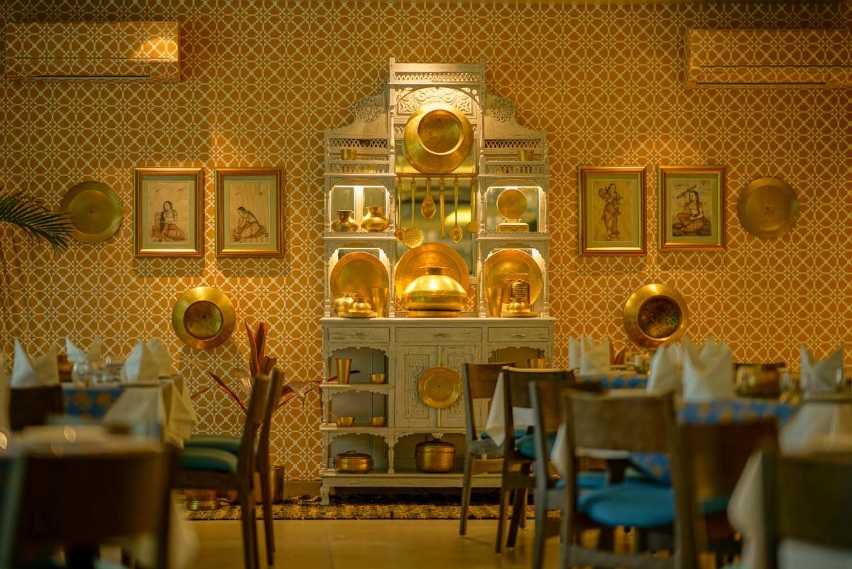a dining room with a clock on the wall at Anand Kashi by the Ganges Rishikesh - IHCL Seleqtions in Rishīkesh