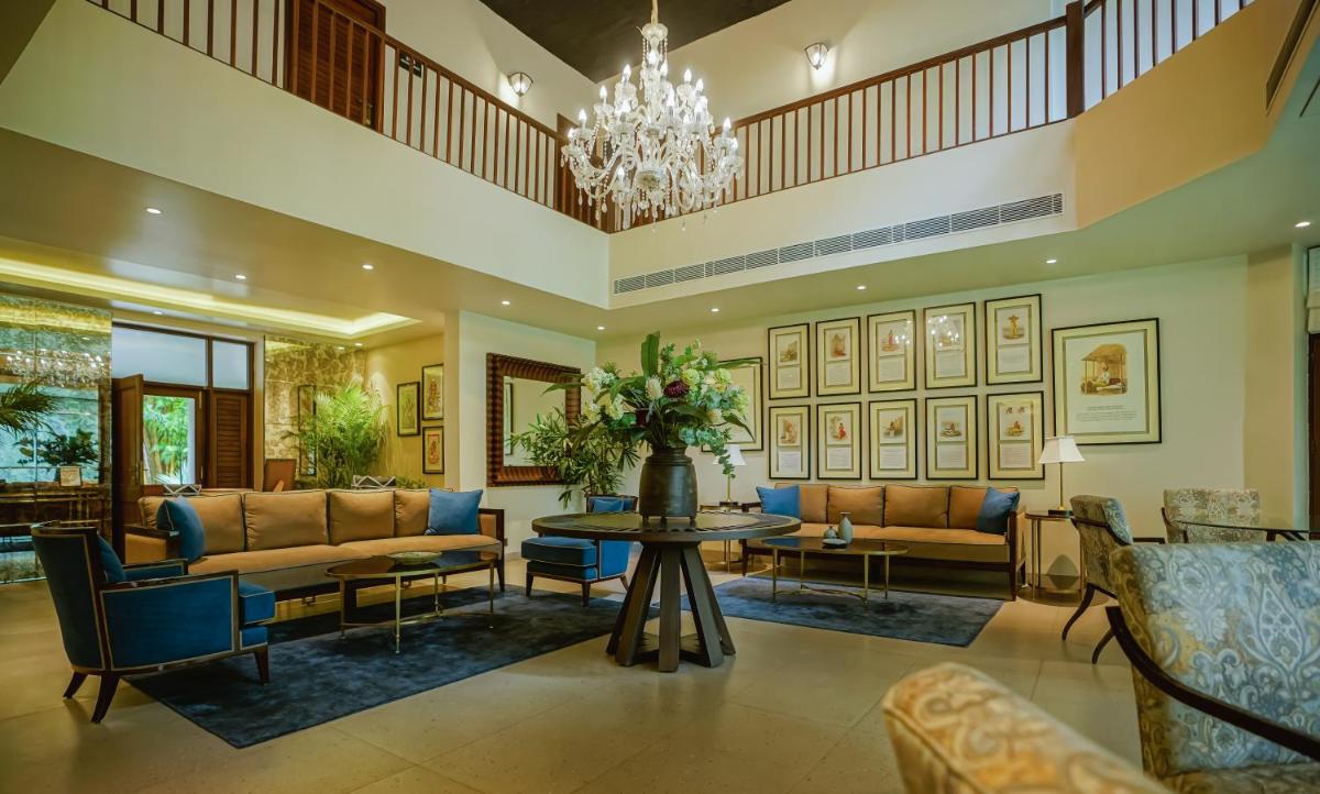 a living room with couches and a table and a chandelier at Anand Kashi by the Ganges Rishikesh - IHCL Seleqtions in Rishīkesh