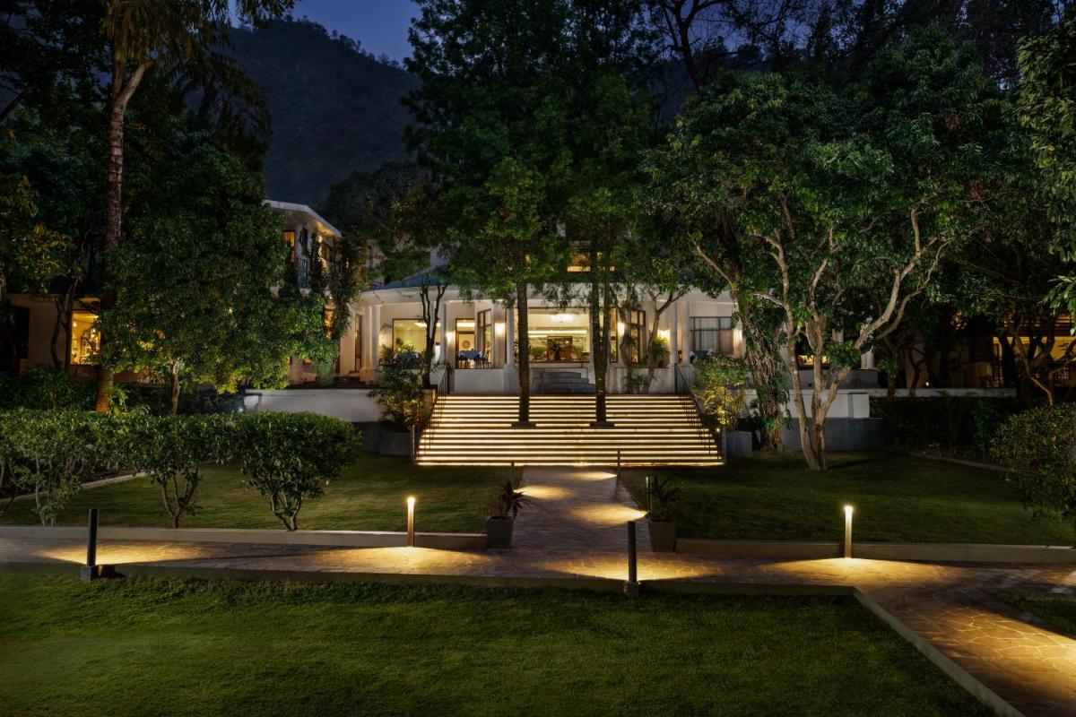 a house with lights in the yard at night at Anand Kashi by the Ganges Rishikesh - IHCL Seleqtions in Rishīkesh