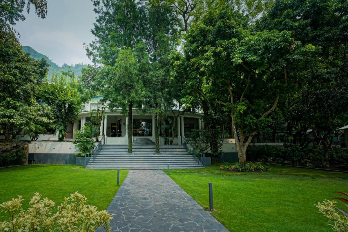 a house with stairs in the front of a yard at Anand Kashi by the Ganges Rishikesh - IHCL Seleqtions in Rishīkesh