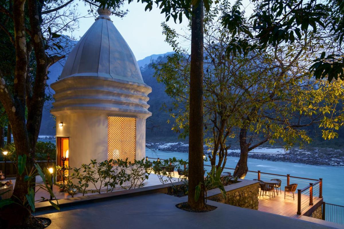 a pavilion with a table and chairs next to a lake at Anand Kashi by the Ganges Rishikesh - IHCL Seleqtions in Rishīkesh