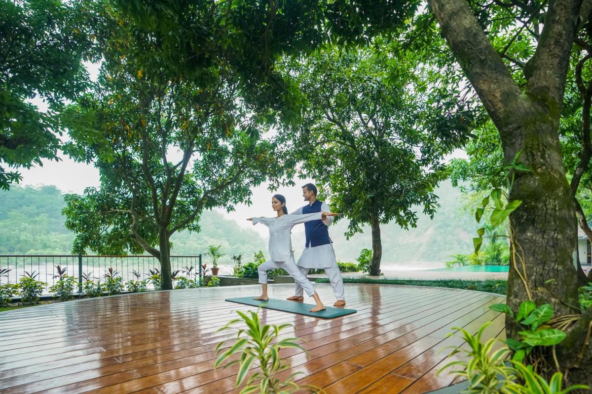 a man and a woman dancing on a wood floor at Anand Kashi by the Ganges Rishikesh - IHCL Seleqtions in Rishīkesh