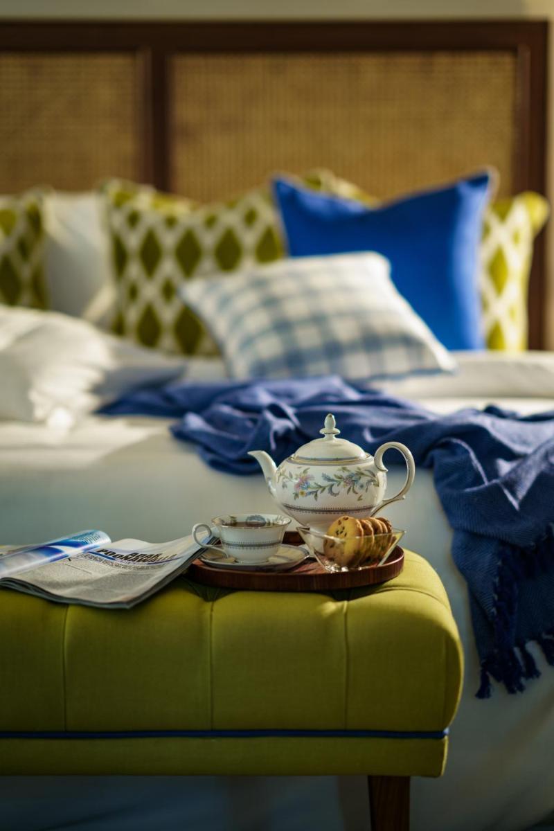 a tea set sitting on a stool next to a bed at Anand Kashi by the Ganges Rishikesh - IHCL Seleqtions in Rishīkesh
