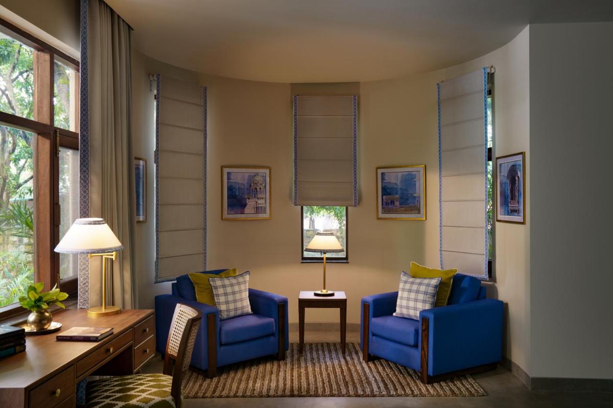 a living room with two blue chairs and a table at Anand Kashi by the Ganges Rishikesh - IHCL Seleqtions in Rishīkesh