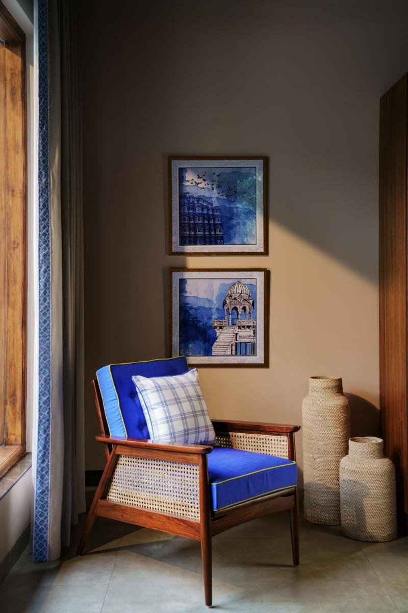 a blue chair sitting next to a window in a room at Anand Kashi by the Ganges Rishikesh - IHCL Seleqtions in Rishīkesh