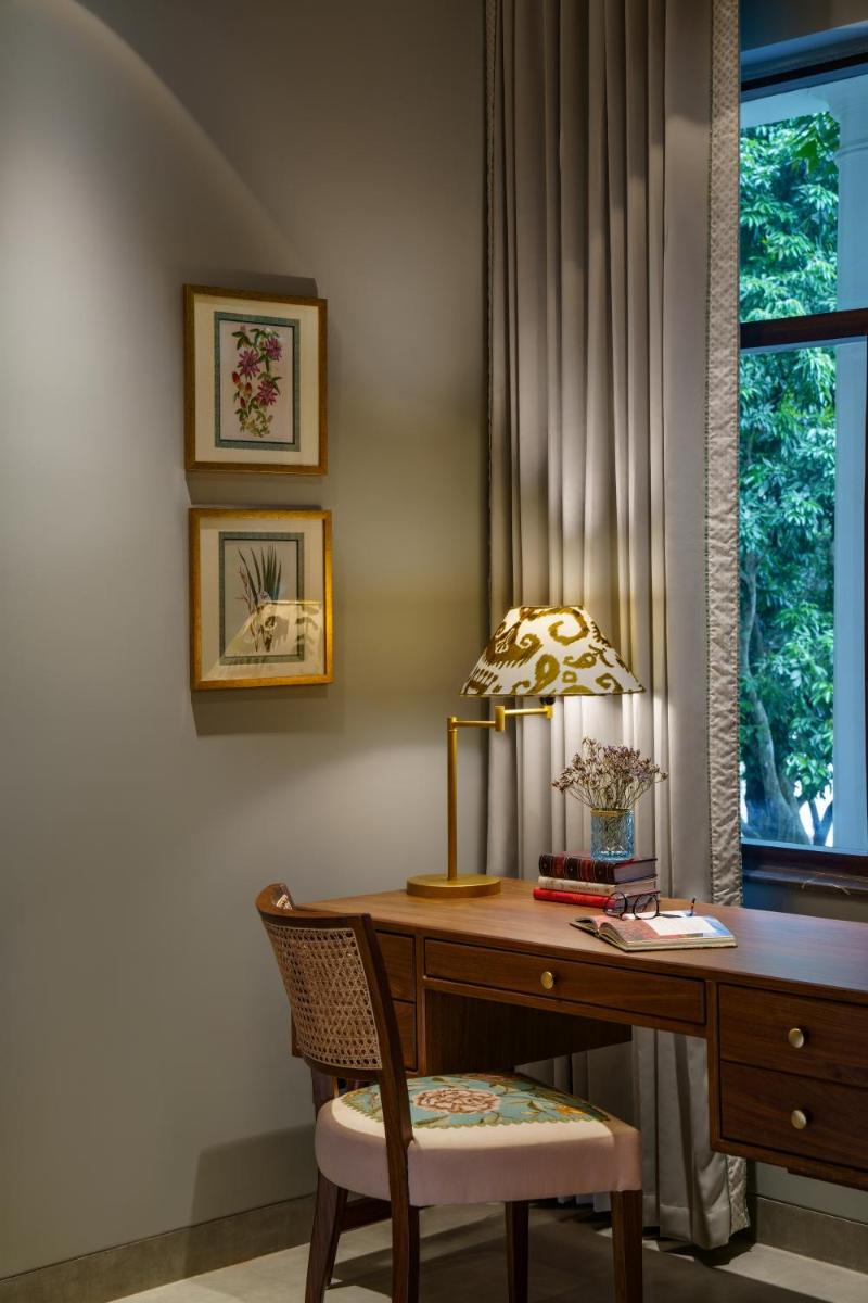a desk with a lamp and a chair next to a window at Anand Kashi by the Ganges Rishikesh - IHCL Seleqtions in Rishīkesh