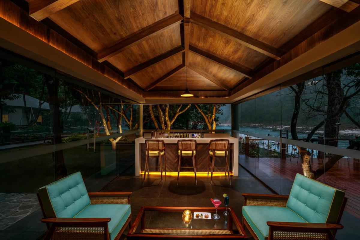 an outdoor living room with a table and chairs at Anand Kashi by the Ganges Rishikesh - IHCL Seleqtions in Rishīkesh