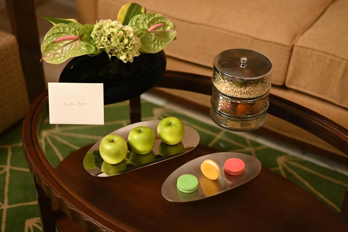 a table with a plate of pears and a vase at The Imperial, New Delhi in New Delhi a table with a plate of pears and a vase at The Imperial, New Delhi in New Delhi