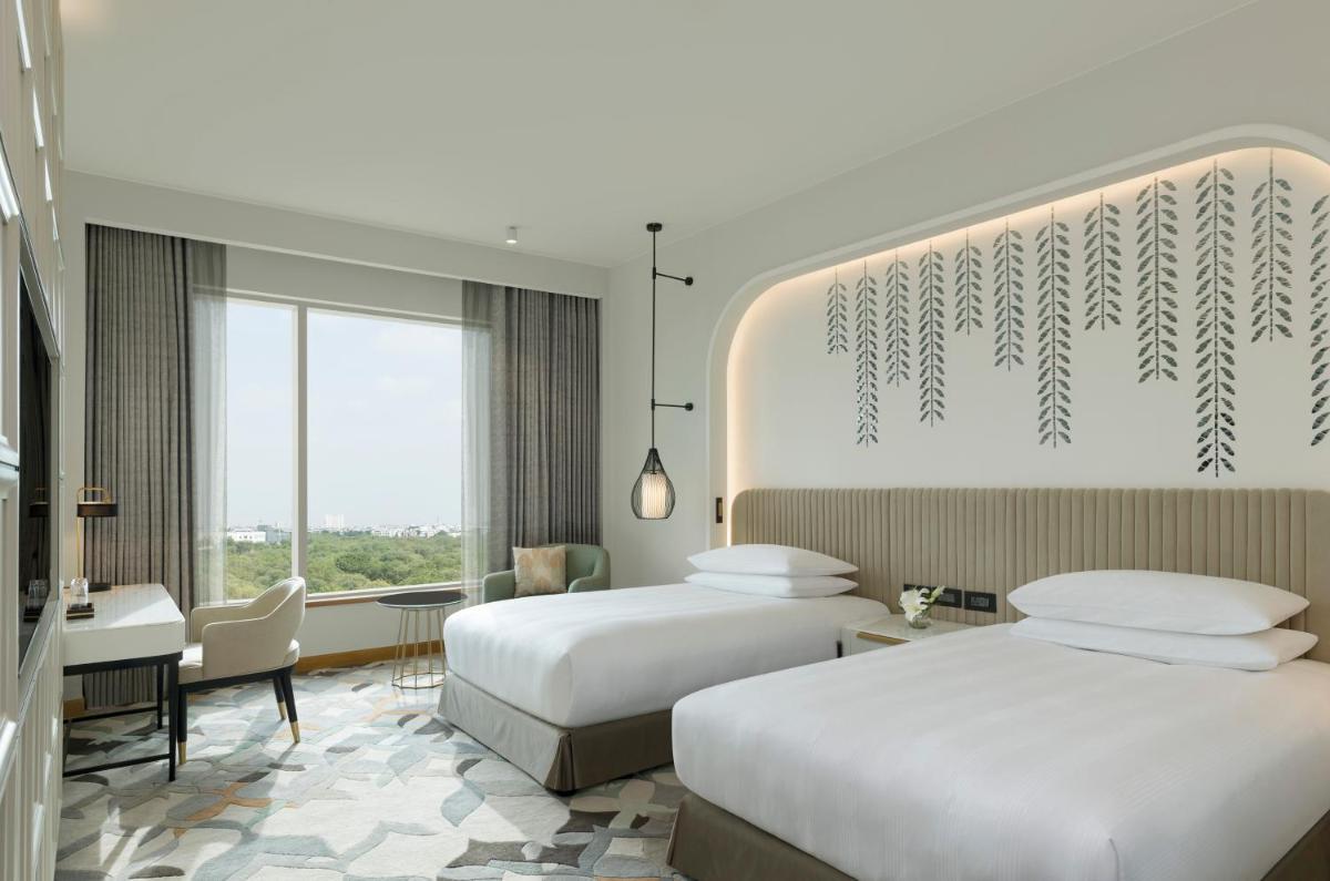 a hotel room with two beds and a desk at InterContinental Jaipur Tonk Road by IHG in Jaipur