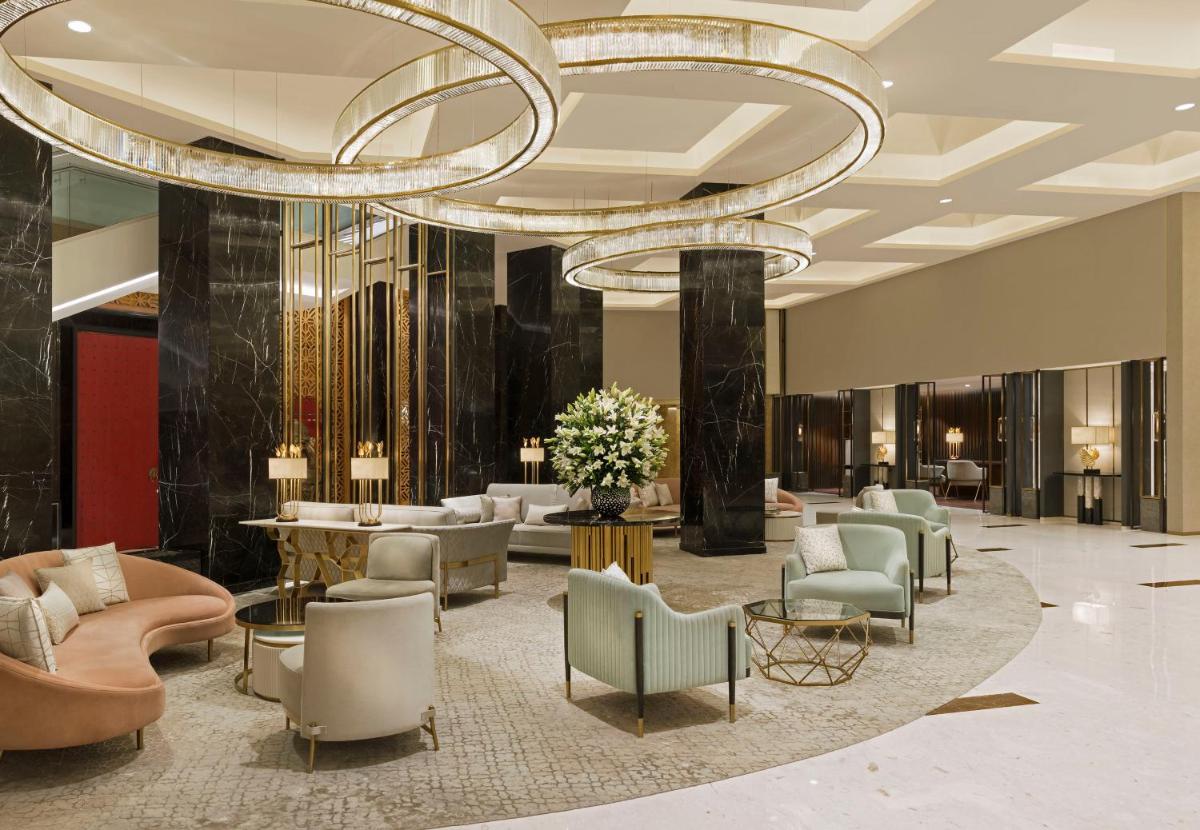 a lobby with a large chandelier and chairs and tables at InterContinental Jaipur Tonk Road by IHG in Jaipur