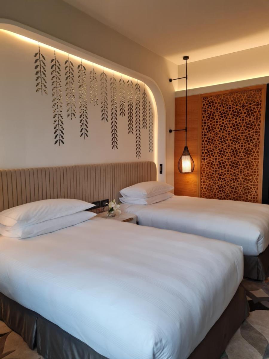 two beds in a hotel room with white sheets at InterContinental Jaipur Tonk Road by IHG in Jaipur