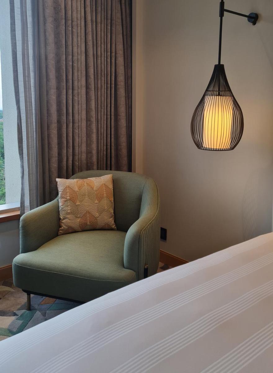 a bedroom with a chair and a pendant lamp at InterContinental Jaipur Tonk Road by IHG in Jaipur