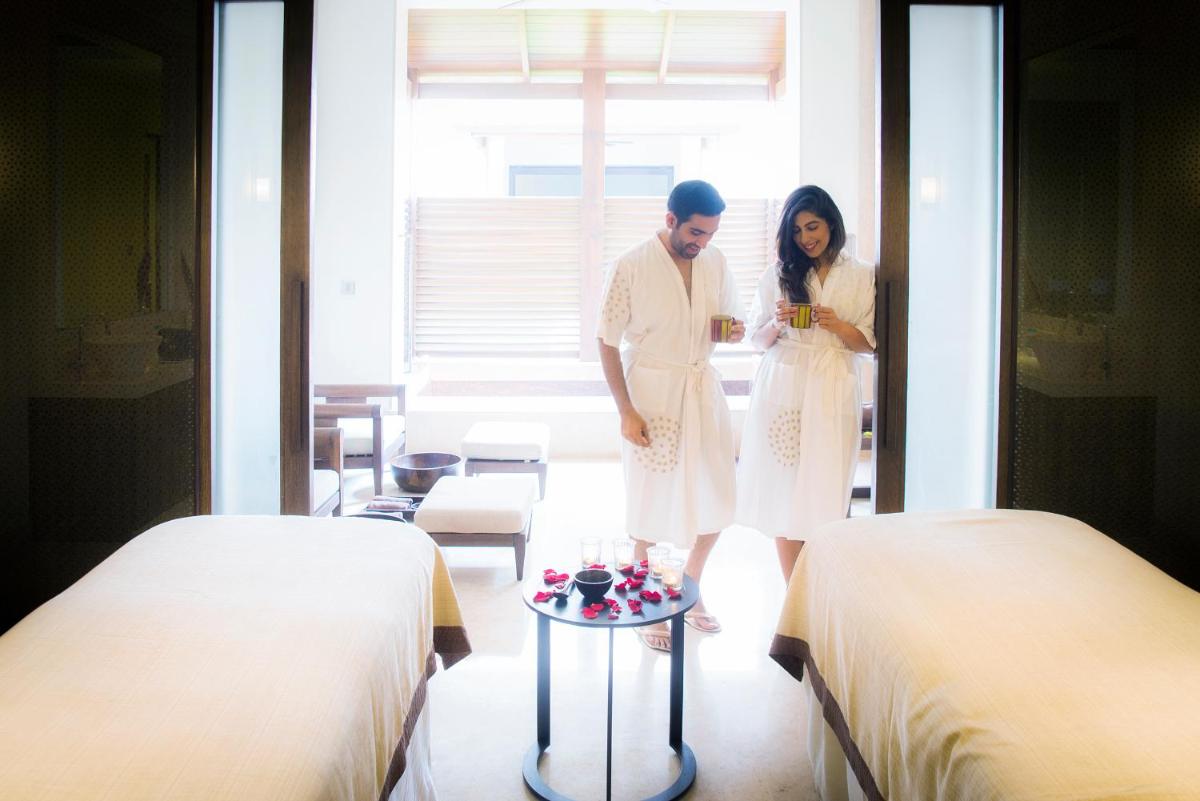 a man and woman standing in a room with beds at Grand Hyatt Goa in Panaji a man and woman standing in a room with beds at Grand Hyatt Goa in Panaji