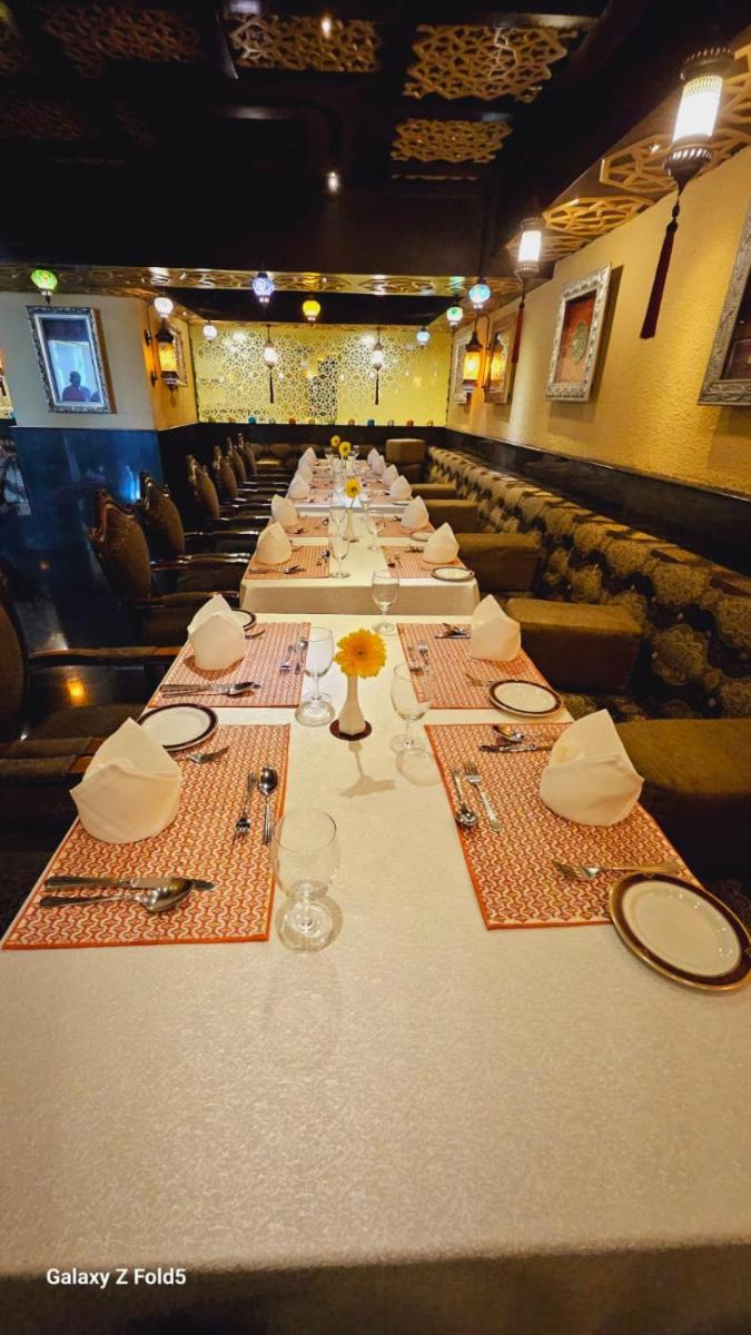 a long table with plates and napkins on it at Sterlings Mac Hotel in Bengaluru