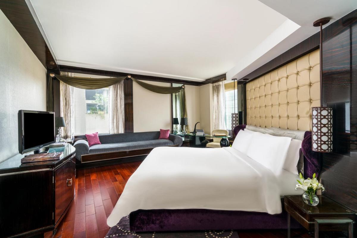 a bedroom with a large white bed and a couch at Sofitel Mumbai BKC in Mumbai