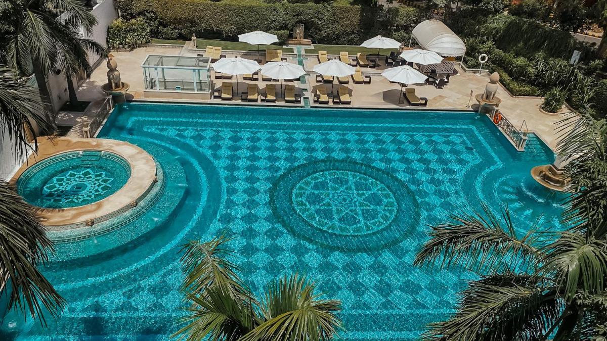 an aerial view of a large swimming pool with umbrellas at The Imperial, New Delhi in New Delhi an aerial view of a large swimming pool with umbrellas at The Imperial, New Delhi in New Delhi
