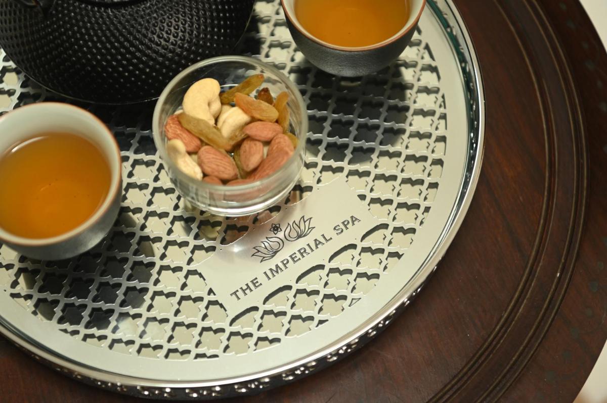 a plate with a bowl of peanuts and a cup of tea at The Imperial, New Delhi in New Delhi a plate with a bowl of peanuts and a cup of tea at The Imperial, New Delhi in New Delhi