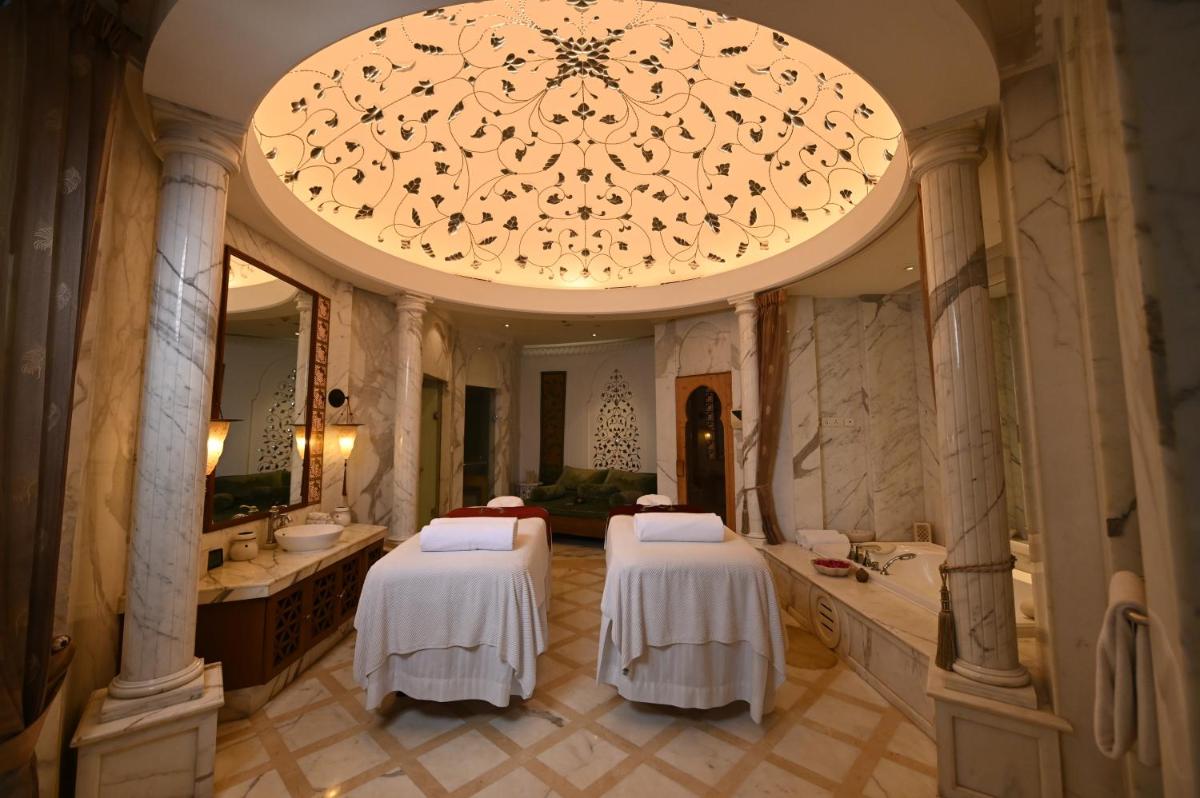 a bathroom with three beds and a large chandelier at The Imperial, New Delhi in New Delhi a bathroom with three beds and a large chandelier at The Imperial, New Delhi in New Delhi