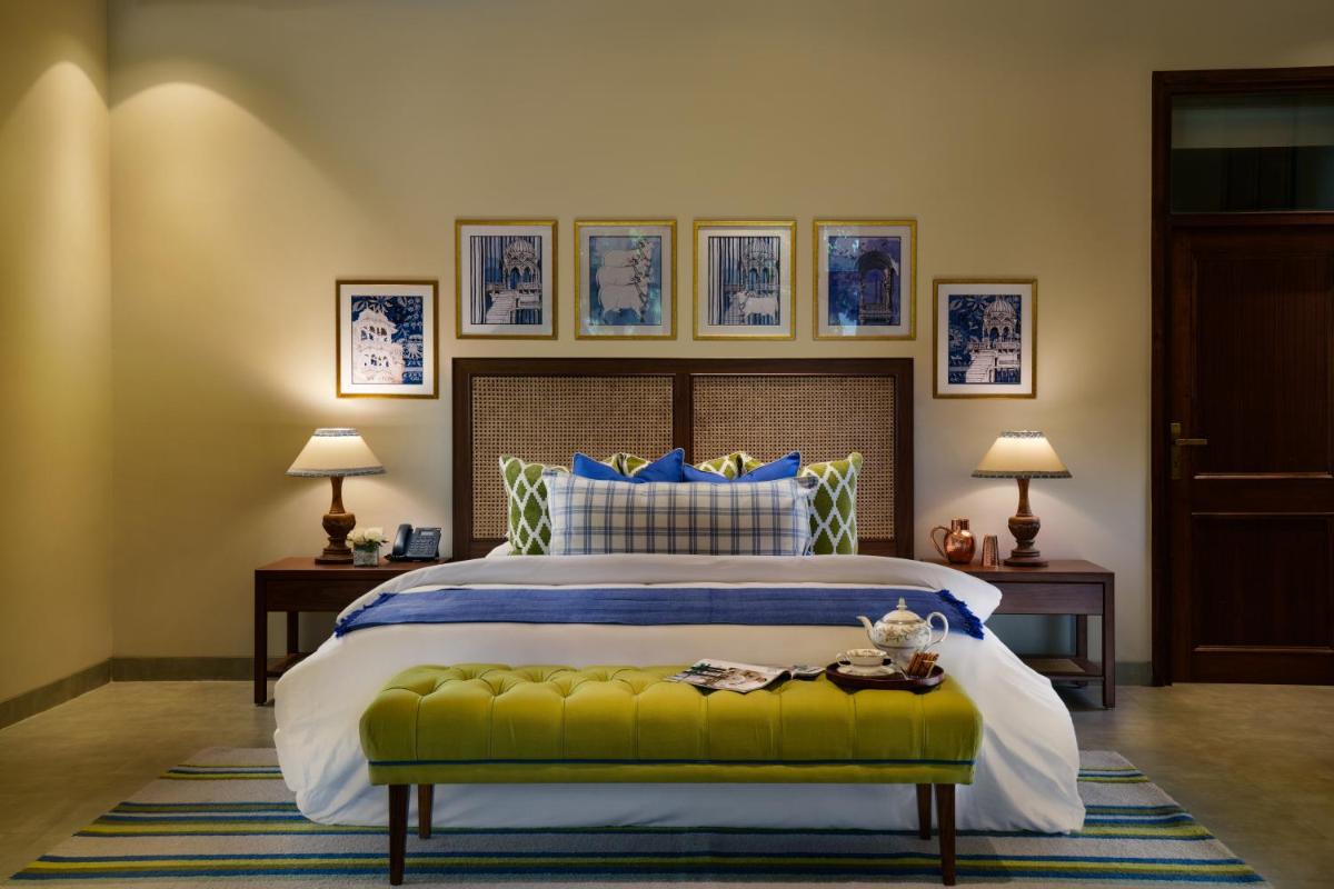 a bedroom with a large bed with a green bench at Anand Kashi by the Ganges Rishikesh - IHCL Seleqtions in Rishīkesh
