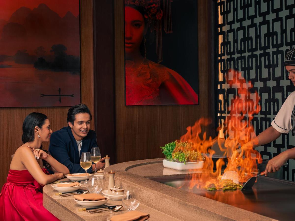 a group of people sitting at a table in a restaurant at Hyatt Pune in Pune