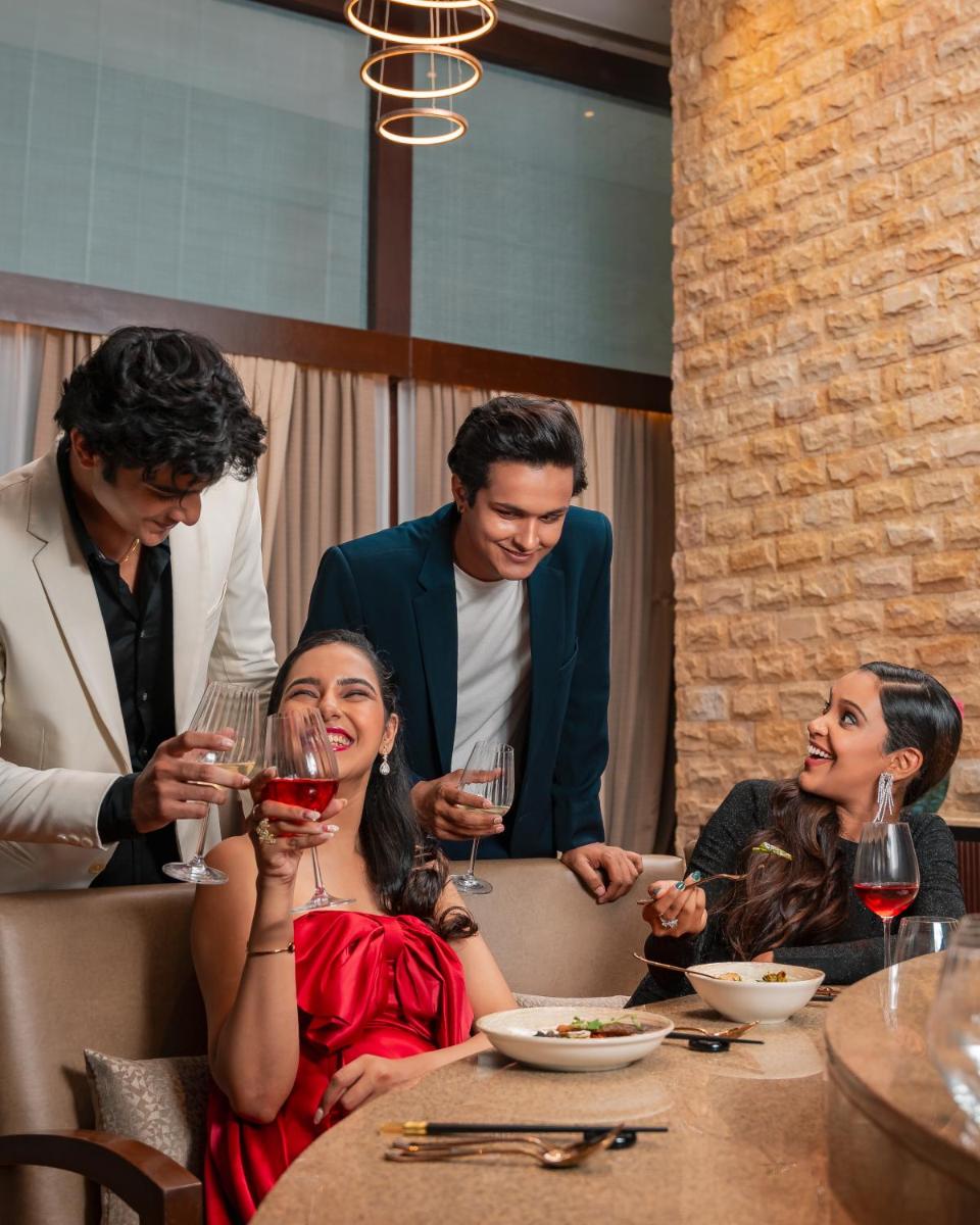 a group of people sitting at a table drinking wine at Hyatt Pune in Pune