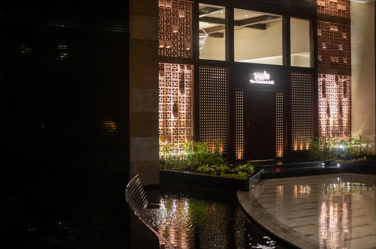 a hotel lobby with a pool at night at Hyatt Pune in Pune