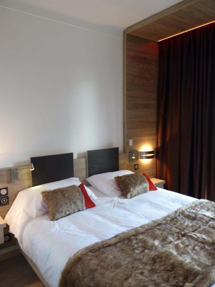 une chambre avec un grand lit avec deux oreillers dessus dans l'établissement Hotel et Résidence Le Clos Cerdan, à Mont-Louis 42 autres photos