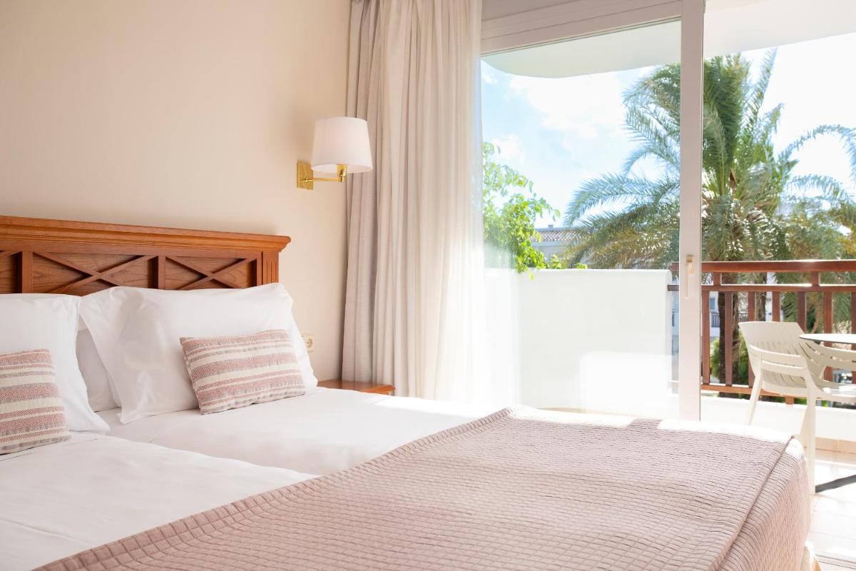 Un dormitorio con una cama blanca y un balcón. en Inturotel Cala Azul, en Cala d´Or 61 fotos más