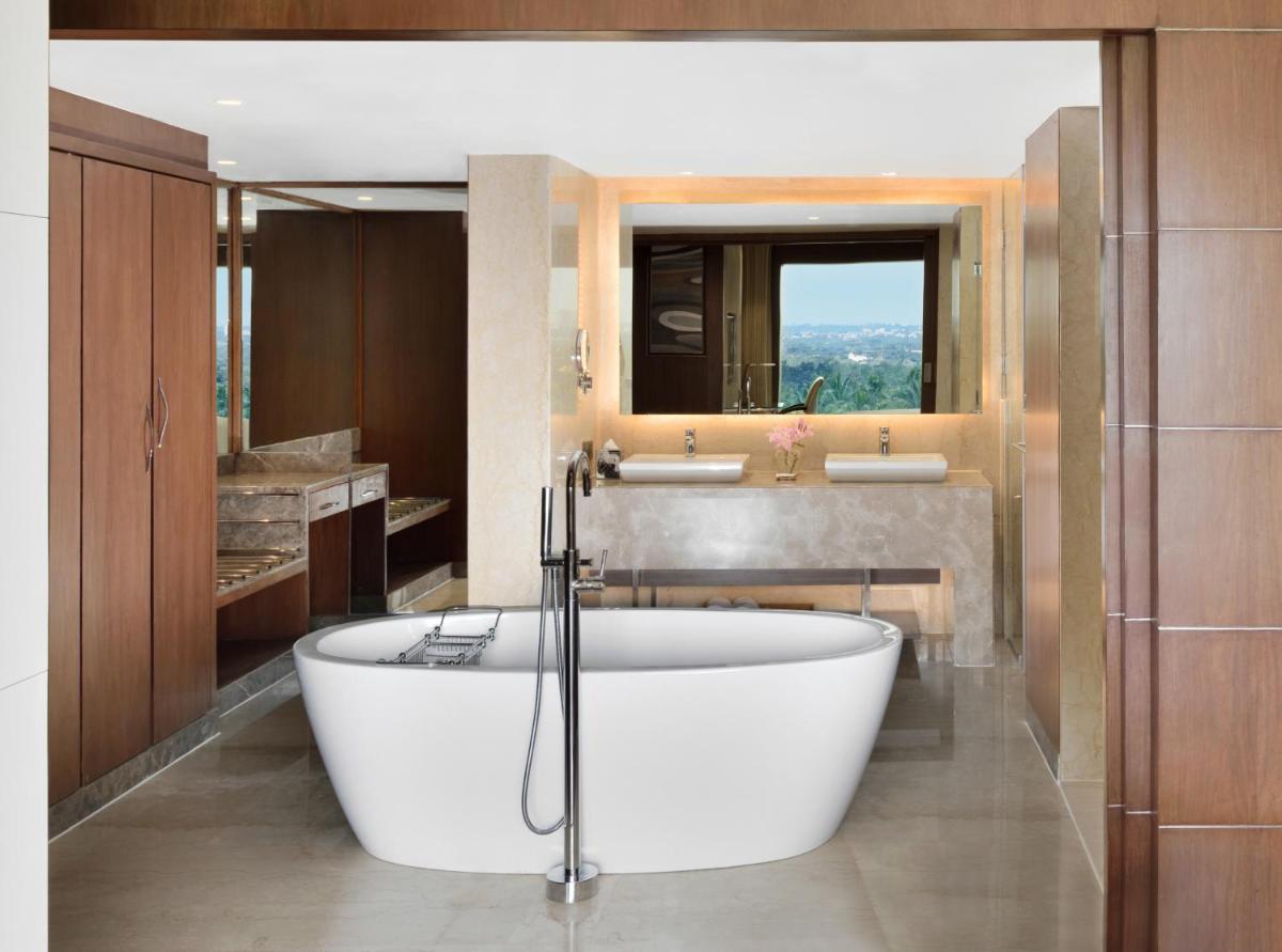 a bathroom with a large tub and a sink at Courtyard by Marriott Bengaluru Hebbal in Bengaluru
