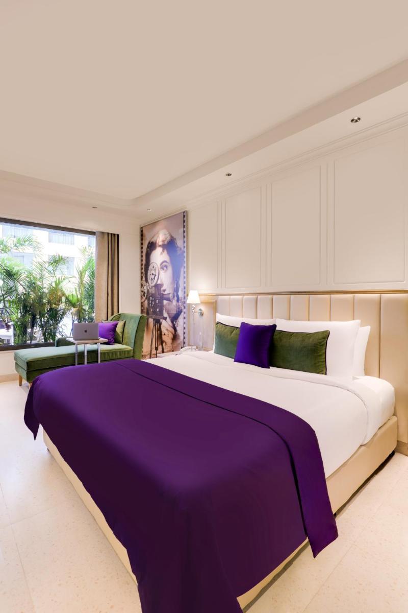 a bedroom with a large bed with purple sheets at Aurika, Mumbai International Airport - Luxury by Lemon Tree Hotels in Mumbai a bedroom with a large bed with purple sheets at Aurika, Mumbai International Airport - Luxury by Lemon Tree Hotels in Mumbai