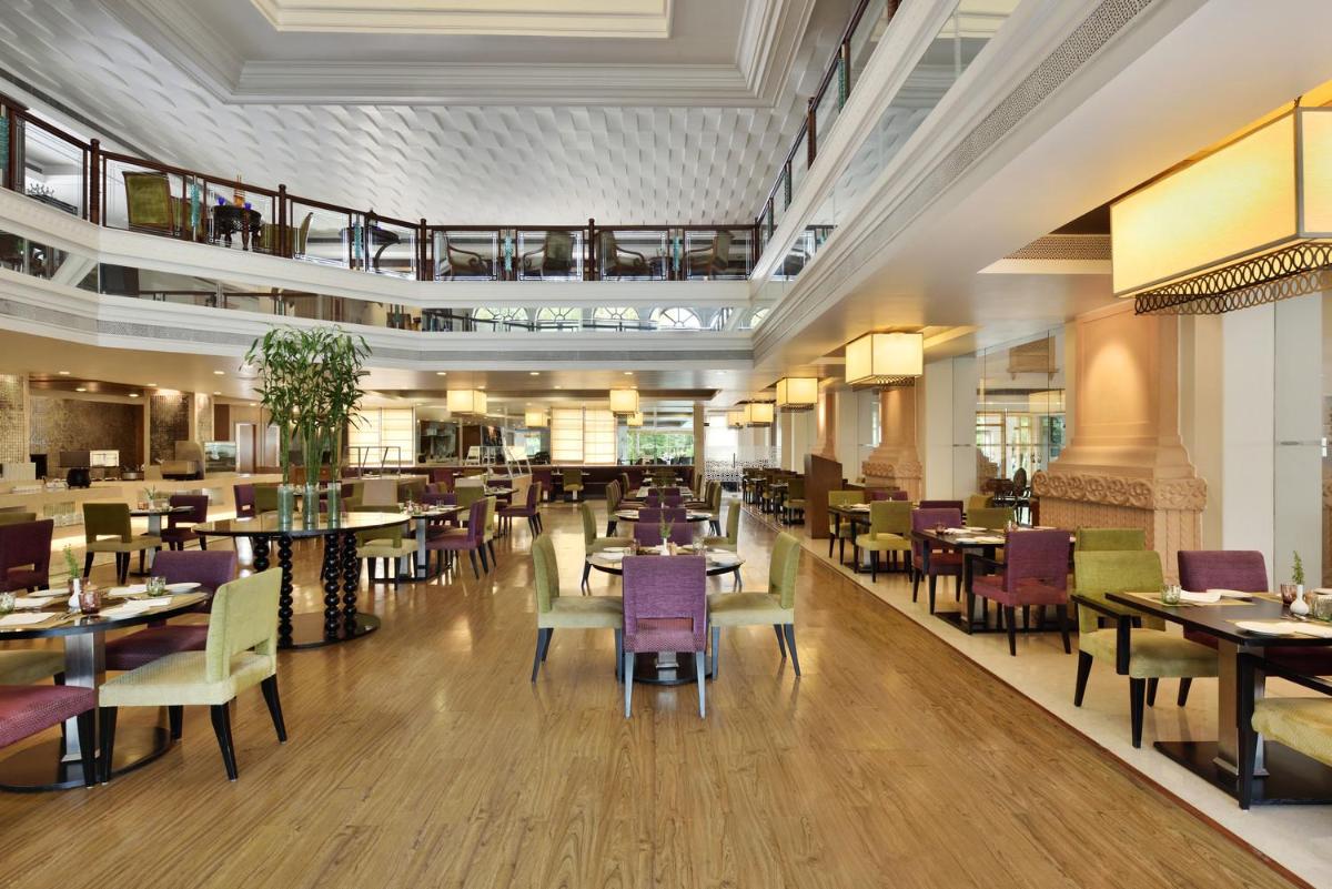 a dining room with tables and chairs and a restaurant at Le Meridien Jaipur Resort & Spa in Jaipur
