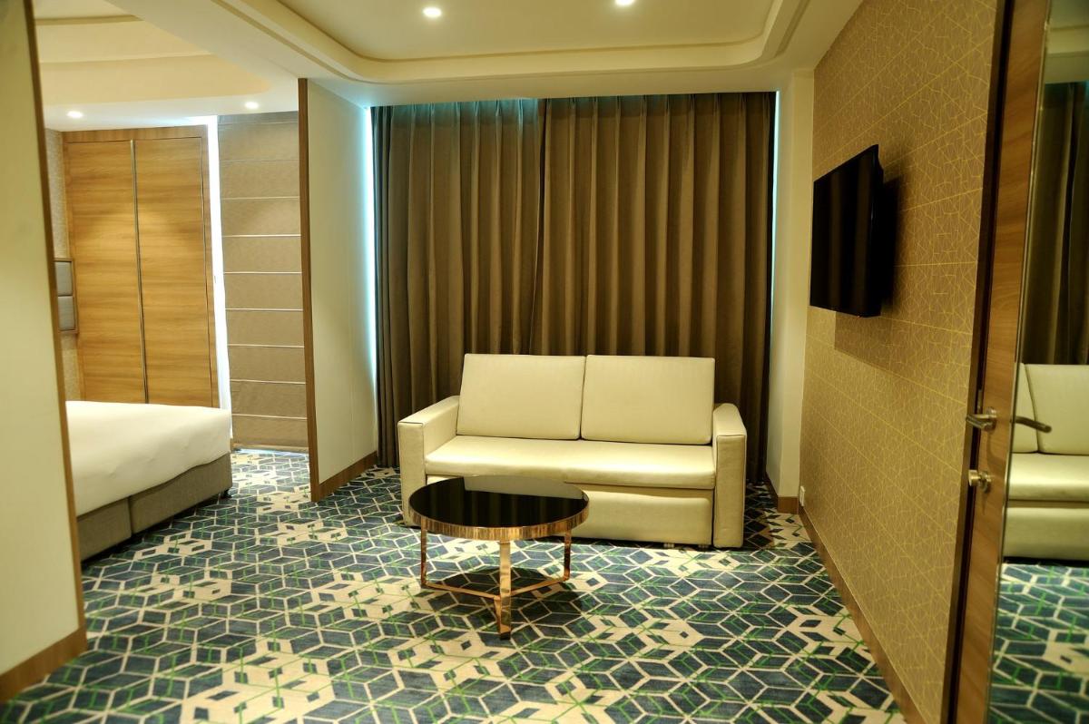a hotel room with a couch and a bed and a table at Holiday Inn Gurugram Sector 90 by IHG in Gurgaon