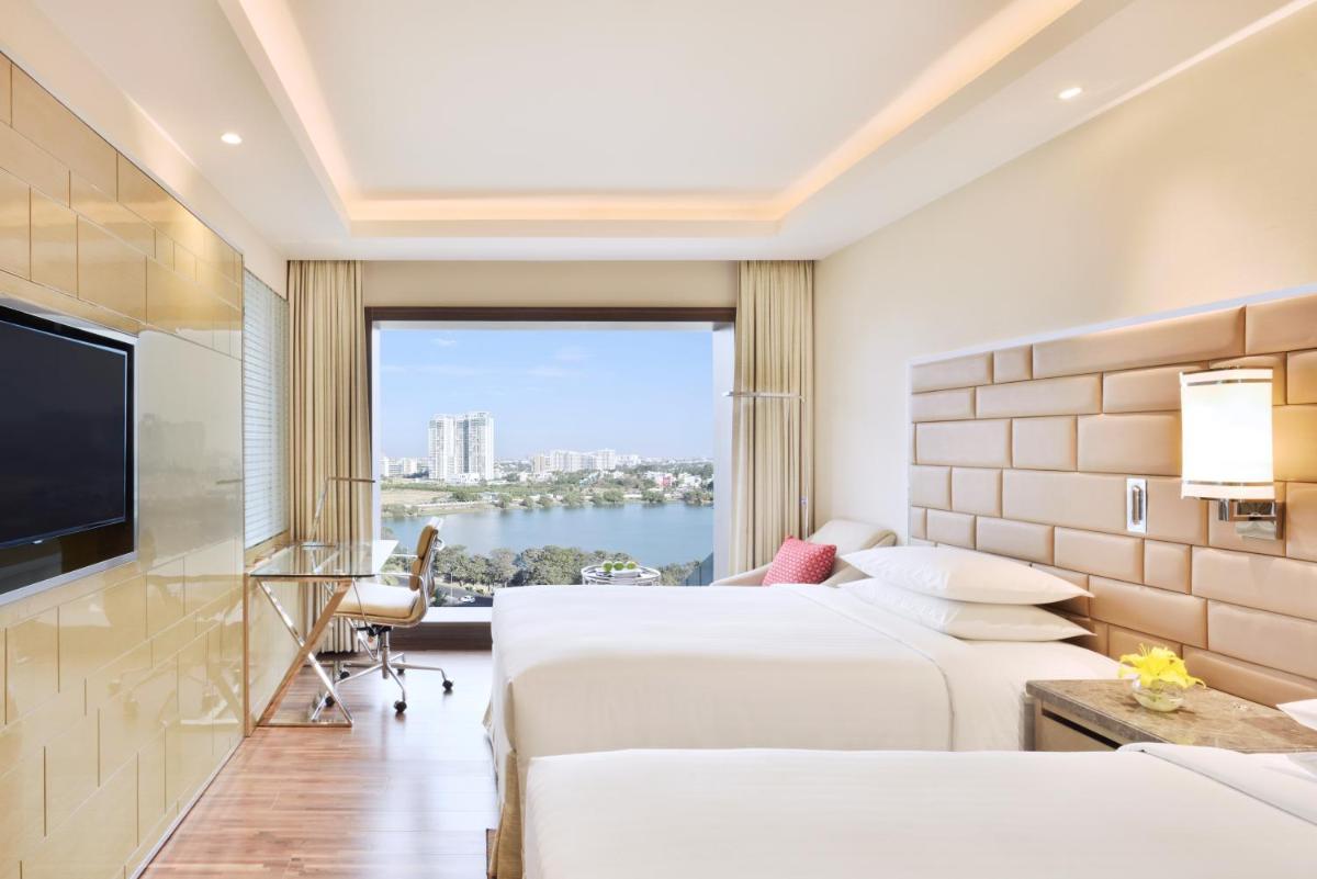 a hotel room with two beds and a large window at Courtyard by Marriott Bengaluru Hebbal in Bengaluru